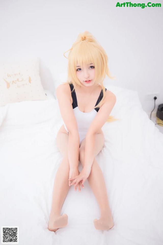 A woman sitting on top of a white bed.