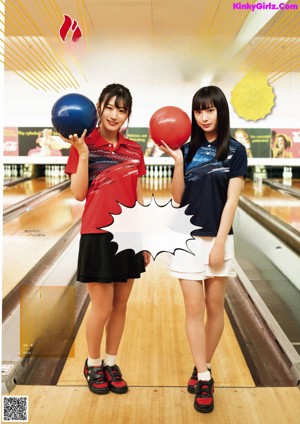 A woman holding a blue bowling ball in her hands.