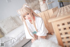 A woman sitting in a wooden crate with a cat ears headband.