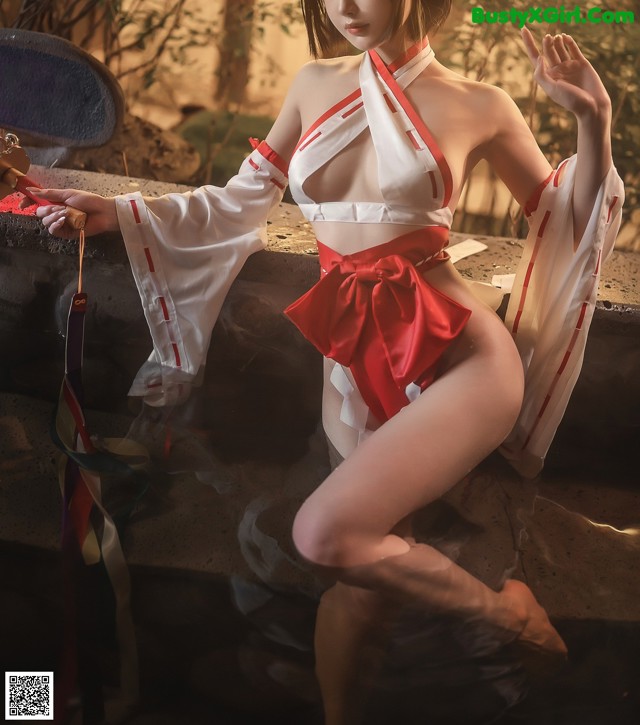 A woman in a red and white kimono posing for a picture.