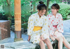 A couple of women sitting next to each other on a bench.