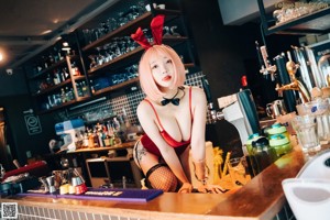 A woman in black stockings and high heels standing in a bar.