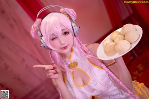 A woman in a pink and white outfit holding a plate of food.