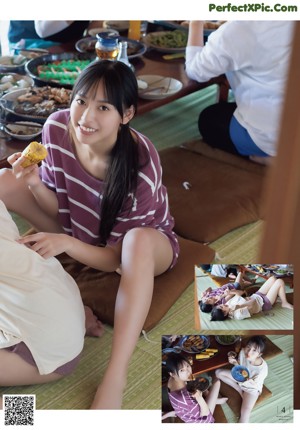 A woman sitting at a table with plates of food.