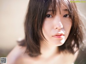 A woman in a yellow bikini posing for a picture.