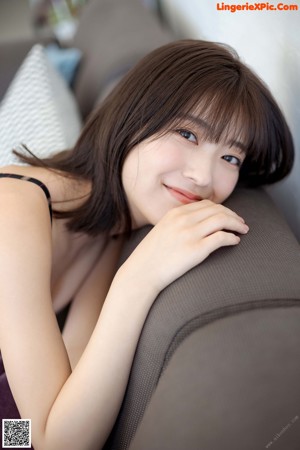 A woman in a plaid bra and panties sitting on a couch.