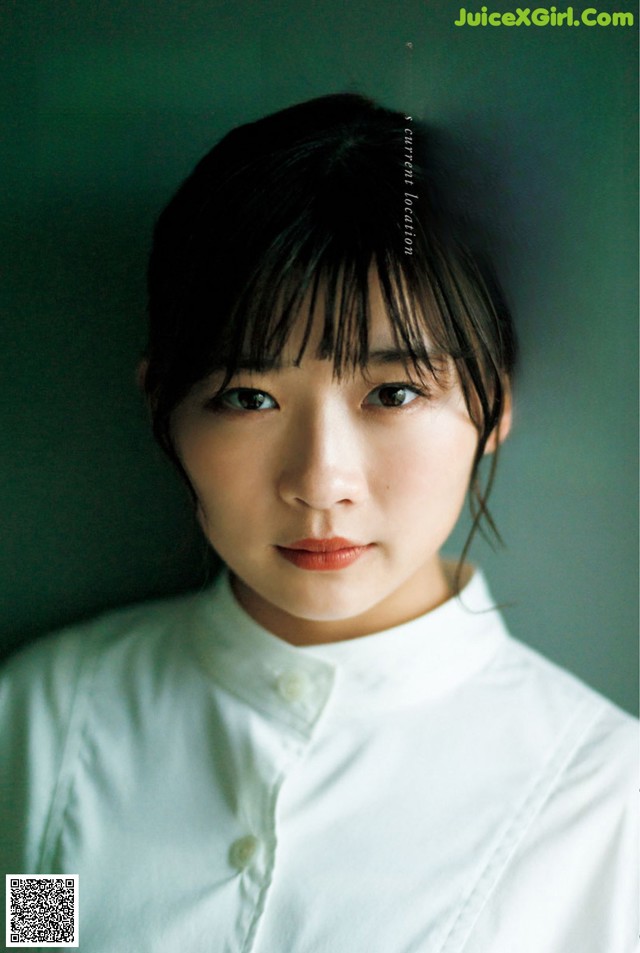 A woman in a white shirt is looking at the camera.