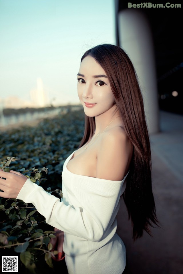 A woman in a white dress posing for a picture.