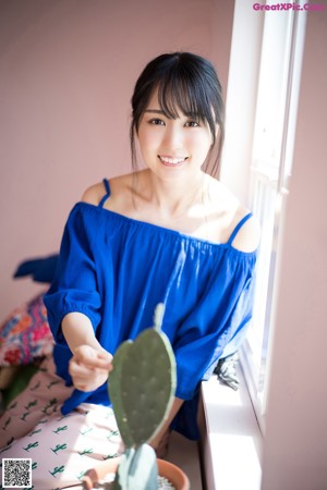 A woman in a blue dress holding a lemon.