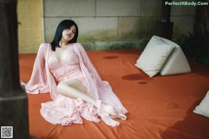 A woman laying on a bed next to a swimming pool.