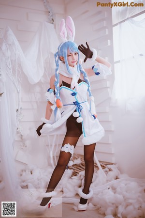 A woman dressed in a maid outfit holding a tray of food.