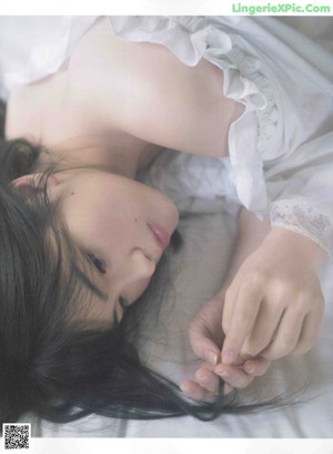 A woman in a white dress and fur coat posing for a magazine.