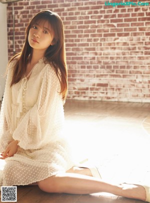 A woman sitting on a window sill wearing a suit.