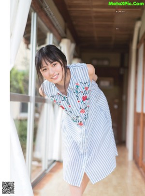 A woman in a pink shirt and blue shorts posing for a picture.