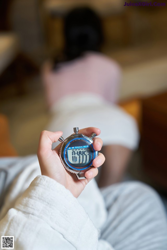 A person holding a digital watch in their hand.