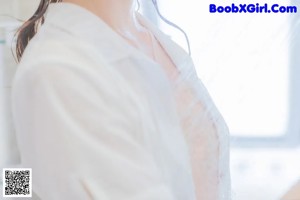 A woman in a white towel is taking a shower.