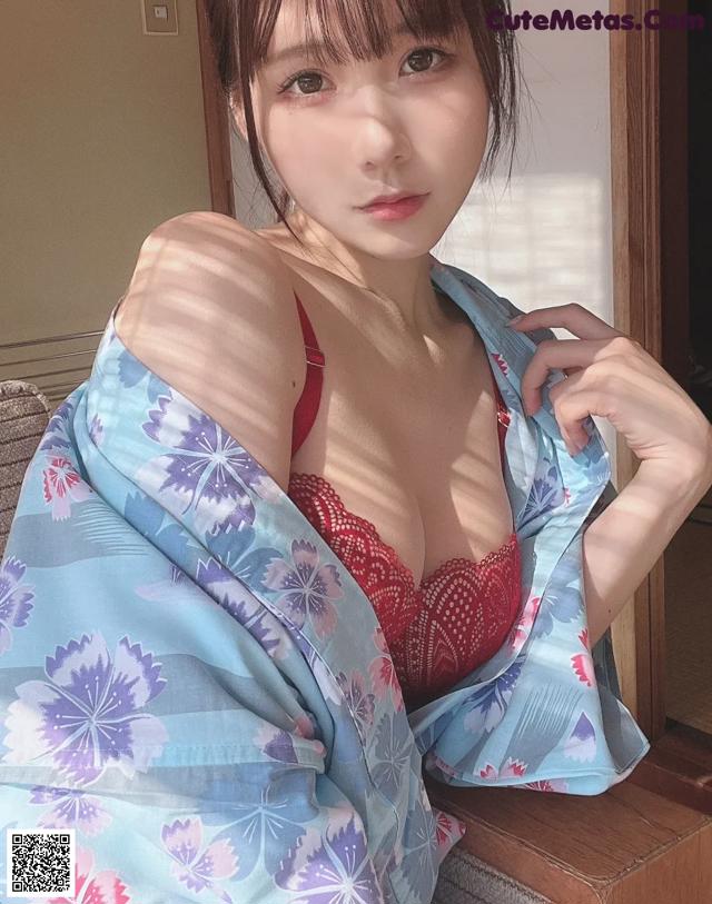 A woman in a red bra top and a blue kimono.