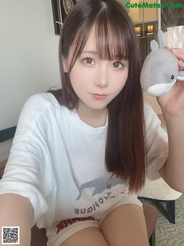 A woman sitting on a couch holding a stuffed animal.