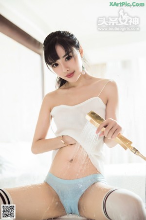 A woman in a white sweater and blue shorts.