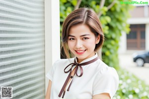 A woman in a white shirt and green skirt sitting on a window sill.