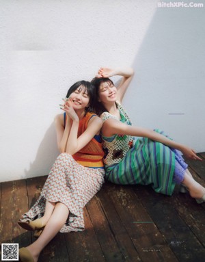 A couple of women standing next to each other on top of a roof.