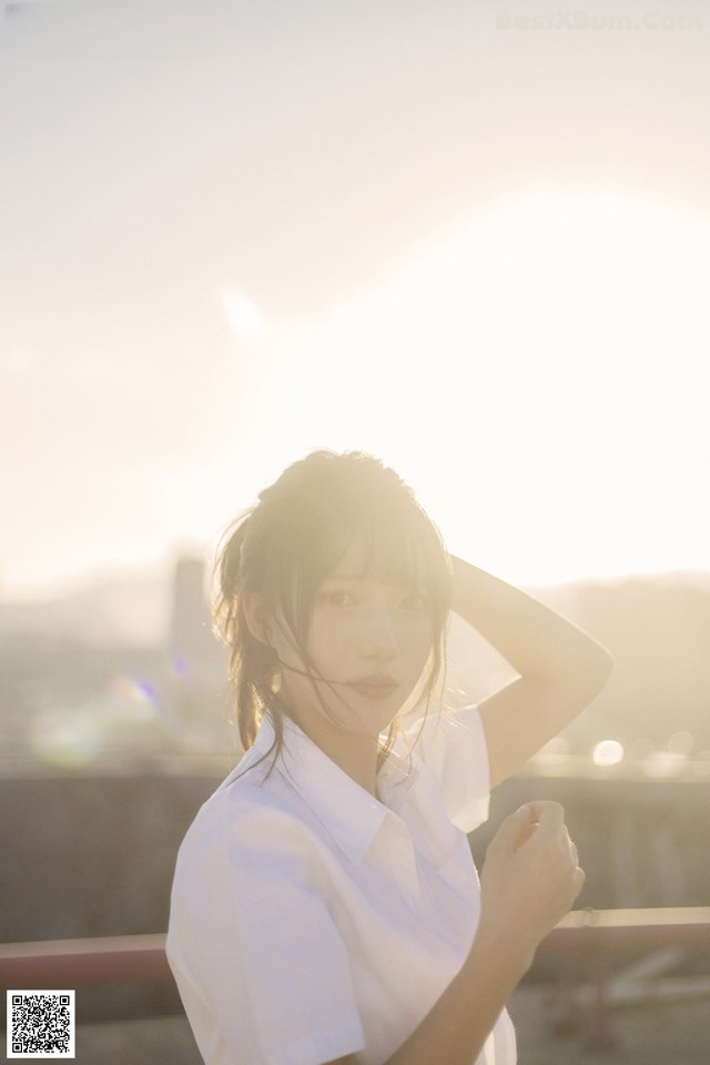 A woman in a white shirt is posing for a picture.