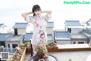 A woman in a white bikini and a floral kimono.