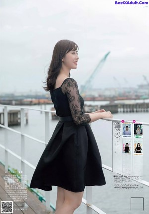 A woman in a black dress posing for a picture.