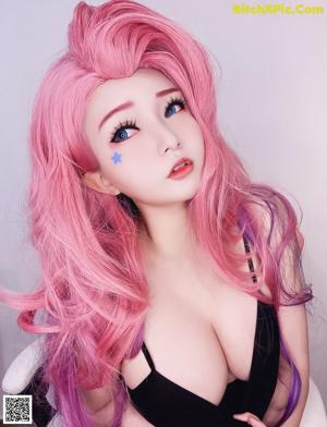 A doll with long pink hair and blue eyes.