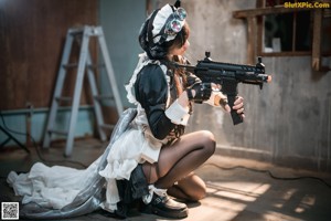 A woman sitting on top of a ladder holding a gun.