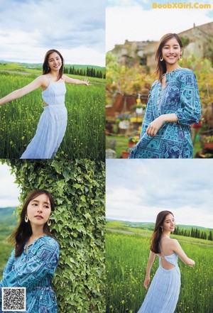 A woman in a blue dress standing in a green field.