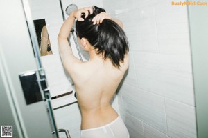 A woman in a white underwear laying on a bed.