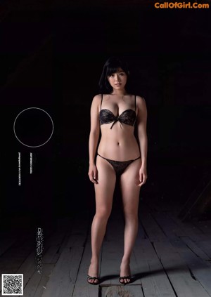 A woman in a black bra and panties posing for a picture.