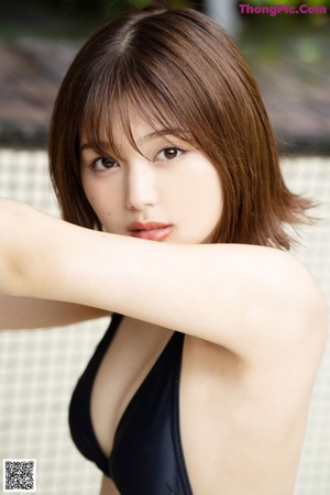 A woman in a black bikini posing for a magazine.