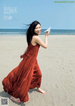 A woman in a bikini holding a flower in her hand.
