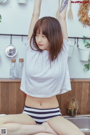 A woman in a white shirt and striped shorts posing for a picture.